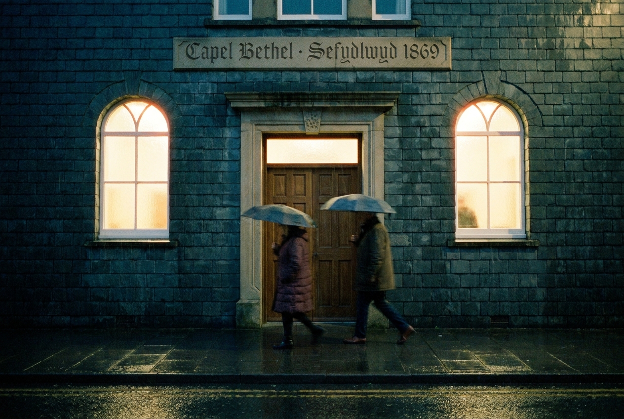 Capel Bethel chapel on a damp evening, light spilling from its arched windows.